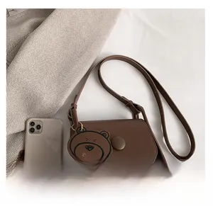 Detail view of brown matte PU crossbody bag showing size comparison with a phone