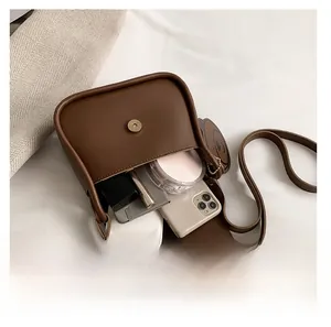 Detail shot showing internal capacity of the dark brown leather crossbody bag