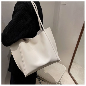 Grand sac cabas blanc minimaliste porté avec une veste en tweed pour un look élégant