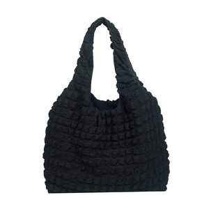 Chic black popcorn fabric tote bag with pleated texture and minimalist shoulder strap design
