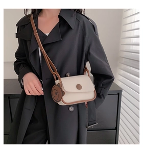 Detail of beige and brown PU leather crossbody bag with cute bear charm and round buckle