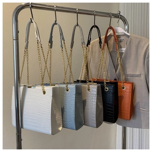 Detail shot of rectangular crocodile pattern shoulder bags with gold chain straps in 5 colors