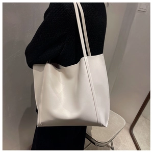 Vue latérale d'un grand sac cabas minimaliste crème avec doubles bretelles robustes