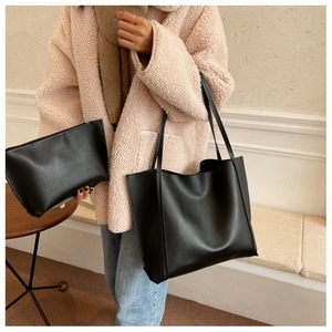 Détail de l'ensemble cabas noir mat avec pochette assortie sur un manteau d'hiver