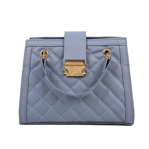 Chic light blue quilted shoulder bag with golden lock hardware on white background