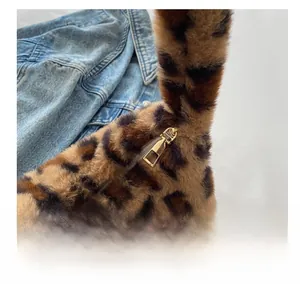 Detail shot of smooth gold metal zipper on leopard print faux fur shoulder bag