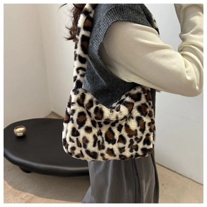 Detail view of stylish leopard print faux fur shoulder bag worn by a model
