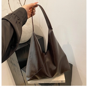 Detail of minimalist dark brown geometric tote bag with textured synthetic leather finish