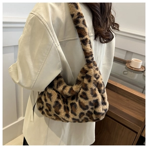 Chic leopard print faux fur hobo bag worn by a model in a cozy indoor setting