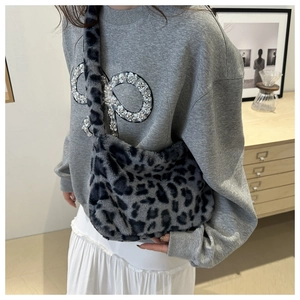 Detail of leopard print faux fur shoulder bag with soft plush texture and wide strap