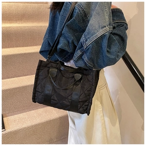 Borsa tote trapuntata con tracolla regolabile mostrata su gradini in esterna