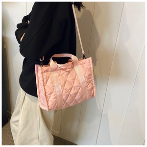 Dettaglio della borsa tote in nylon trapuntato rosa con tracolla indossata da una modella