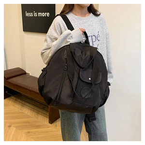 Detail of black large capacity nylon backpack with multiple pockets for travel and commute
