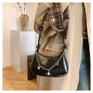 Detail of black crescent shoulder bag with silver chain and heart star pearl charms