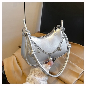 Silver crescent shoulder bag with metallic chain and star charms on a leather strap