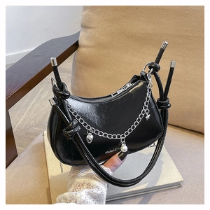 Détail du sac croissant noir en cuir plissé brillant avec chaîne à breloques argent
