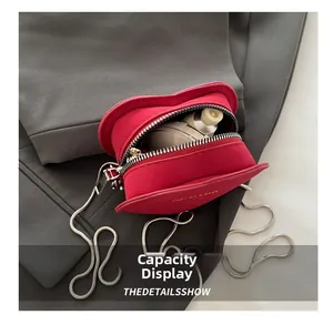 Macro view of compact red heart crossbody bag showing interior capacity for makeup