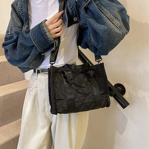 Chic black quilted tote bag with diamond stitching and adjustable shoulder strap