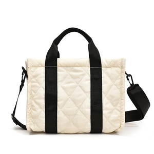 Minimalist beige quilted nylon tote bag with black straps and detachable shoulder strap