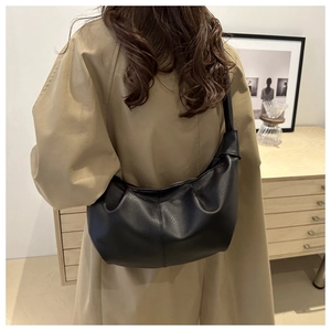 Detail shot of black pebbled leather hobo bag with natural folds and metal zipper