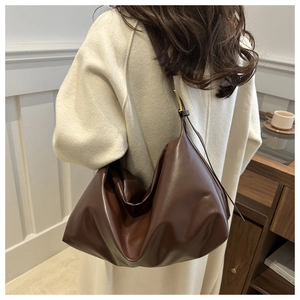 Détail du sac cabas en cuir marron foncé avec texture souple et bandoulière réglable