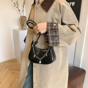 Fashionable black glossy half-moon bag with silver chain and pearl heart charm accessory
