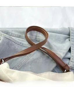 Close-up of durable canvas tote with brown leather strap and silver metal ring detail