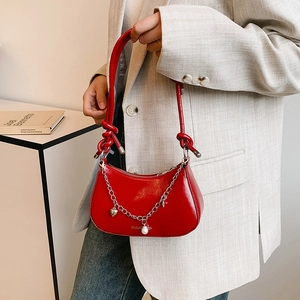 Chic red crescent bag in glossy patent leather with silver chain and heart charm