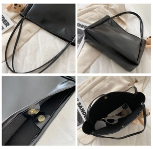 Macro view of black leather tote bag with magnetic bronze clasp and spacious interior