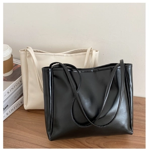 Minimalist large tote bags in black and cream white displayed with lifestyle props