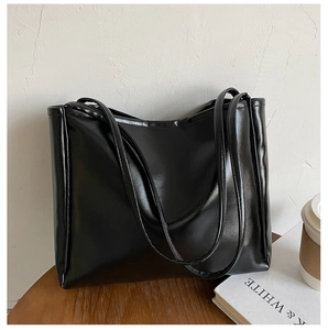 Minimalist black PU leather tote bag shown on a wooden surface for office daily use