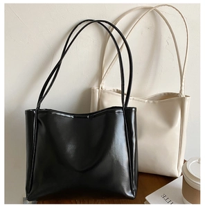 Close-up of black and beige minimalist tote bags in high-quality textured PU leather