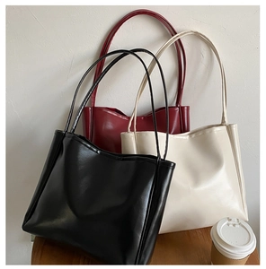 Detailed macro view of minimalist tote bags in black, burgundy and beige faux leather