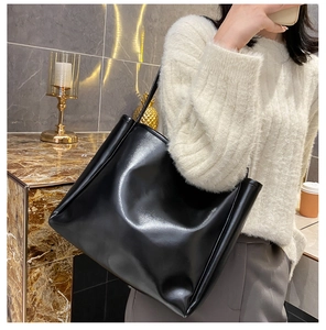 Detail of high-gloss black leather tote bag with vertical stitching for daily use