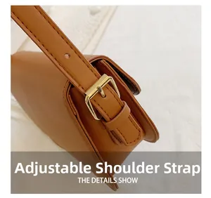 Detail shot of the adjustable brown leather shoulder strap with a gold metal buckle
