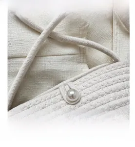 Macro shot of two-tone woven beach bag featuring a polished pearl button closure