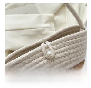 Detail shot of the two-tone woven handbag featuring a large pearl button closure