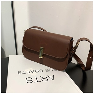 Detail view of a vintage brown leather crossbody bag with a minimalist gold metal clasp