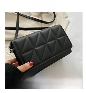 Détail du sac bandoulière noir avec motif matelassé triangulaire et fine lanière