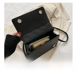 Détail de l'intérieur du sac noir montrant la capacité pour téléphone et portefeuille