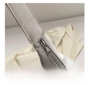 Macro detail of high-quality smooth silver zipper and stitching on white leather bag