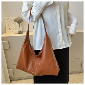 Detailed side view of caramel brown soft hobo bag with high-quality stitching details