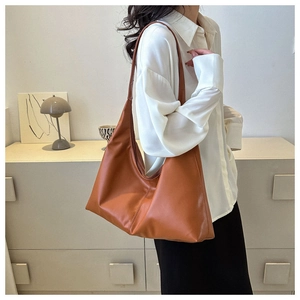 Close-up of caramel brown leather hobo bag with a spacious minimalist shoulder design