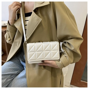 Détail d'un sac à bandoulière matelassé blanc cassé avec motif géométrique