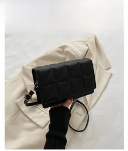 Détail d'un sac bandoulière noir avec surpiqûres géométriques en triangle et fermoir métallique