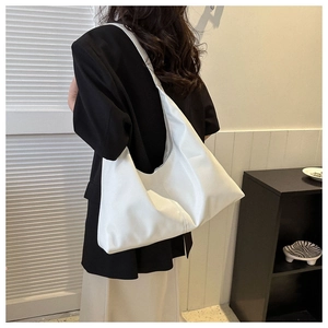 Close-up of a large white PU leather hobo tote bag featuring a minimalist crescent design