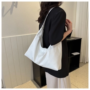 Detailed view of the soft white PU leather texture and slouchy design on the shoulder bag
