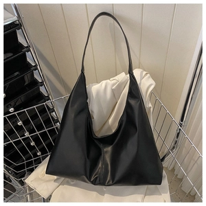 Close-up of a black matte PU leather hobo tote bag with a spacious curved design