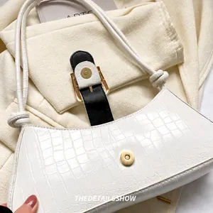 Détail du sac blanc avec motif crocodile et fermoir magnétique doré brillant