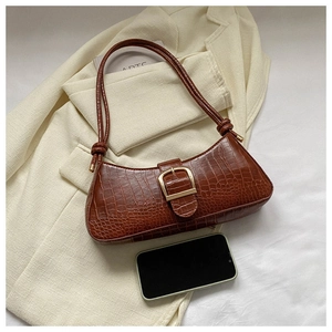 Détail du sac baguette marron en similicuir crocodile avec boucle dorée brillante
